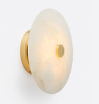 The Clérachic fixture turned edge on, showing how shallow the alabaster disc sits on its brass mount.