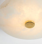 The Clérachic shade's natural veining in detail, warm light drifting across the stone beside a brass cap.