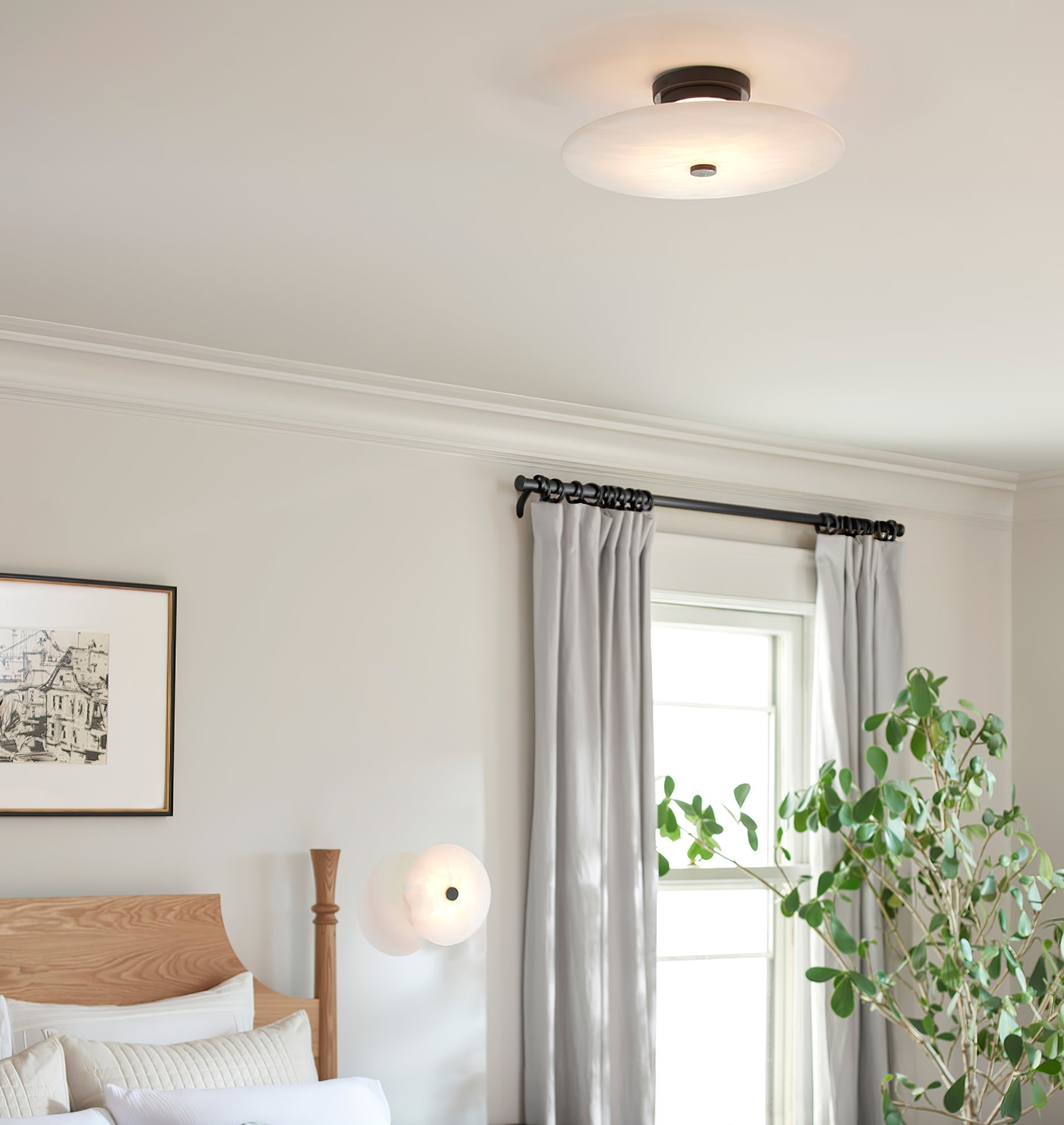 The Clérachic black-finish light on a bedroom ceiling, with a second glowing softly by the curtained window.