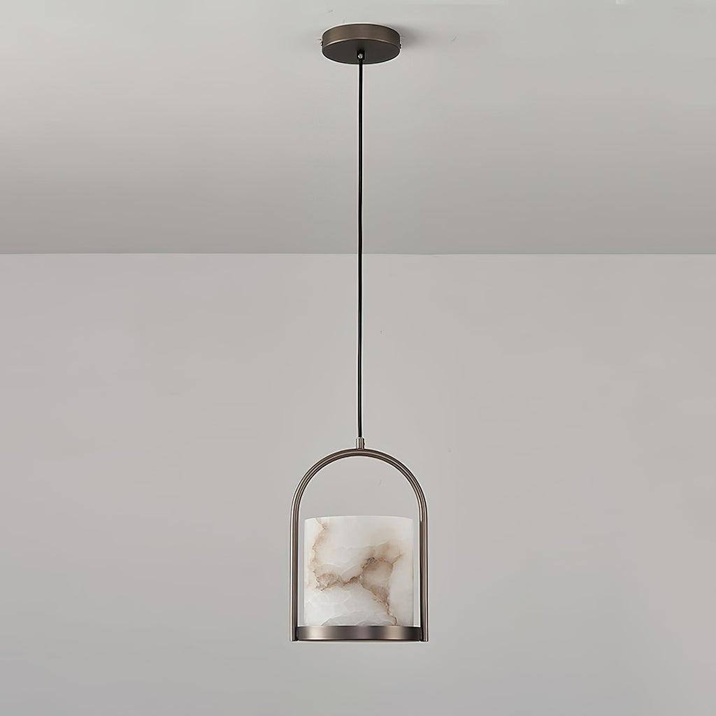 Clérachic Jewel Pendant Light hanging unlit from a grey ceiling, the slim brass arch and stone shade seen from across the room.