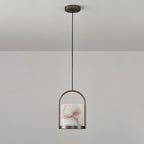 Clérachic Jewel Pendant Light hanging unlit from a grey ceiling, the slim brass arch and stone shade seen from across the room.