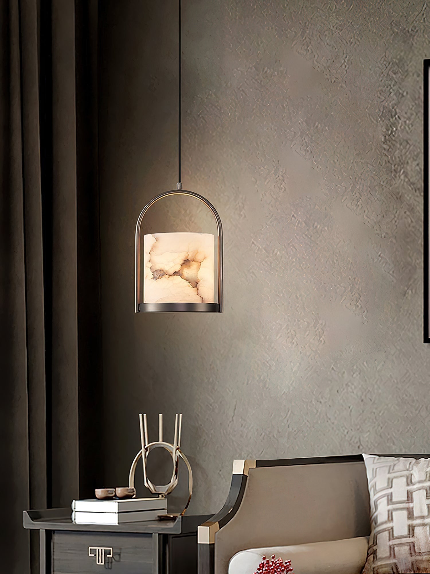 The Clérachic Jewel Pendant Light hung beside a bedside table, throwing a pool of light across a textured grey wall.