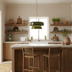 Clérachic green glass pendant in front of a sunlit window in a kitchen, with wooden stools at an island and clay pots on open shelves.