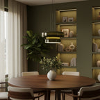 Clérachic dark green glass pendant above a round walnut table, with a fiddle-leaf plant and lit bookshelves in an olive-green room.