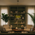 Clérachic green glass pendant lit in front of an olive bookshelf, between two cream armchairs and tall plants.