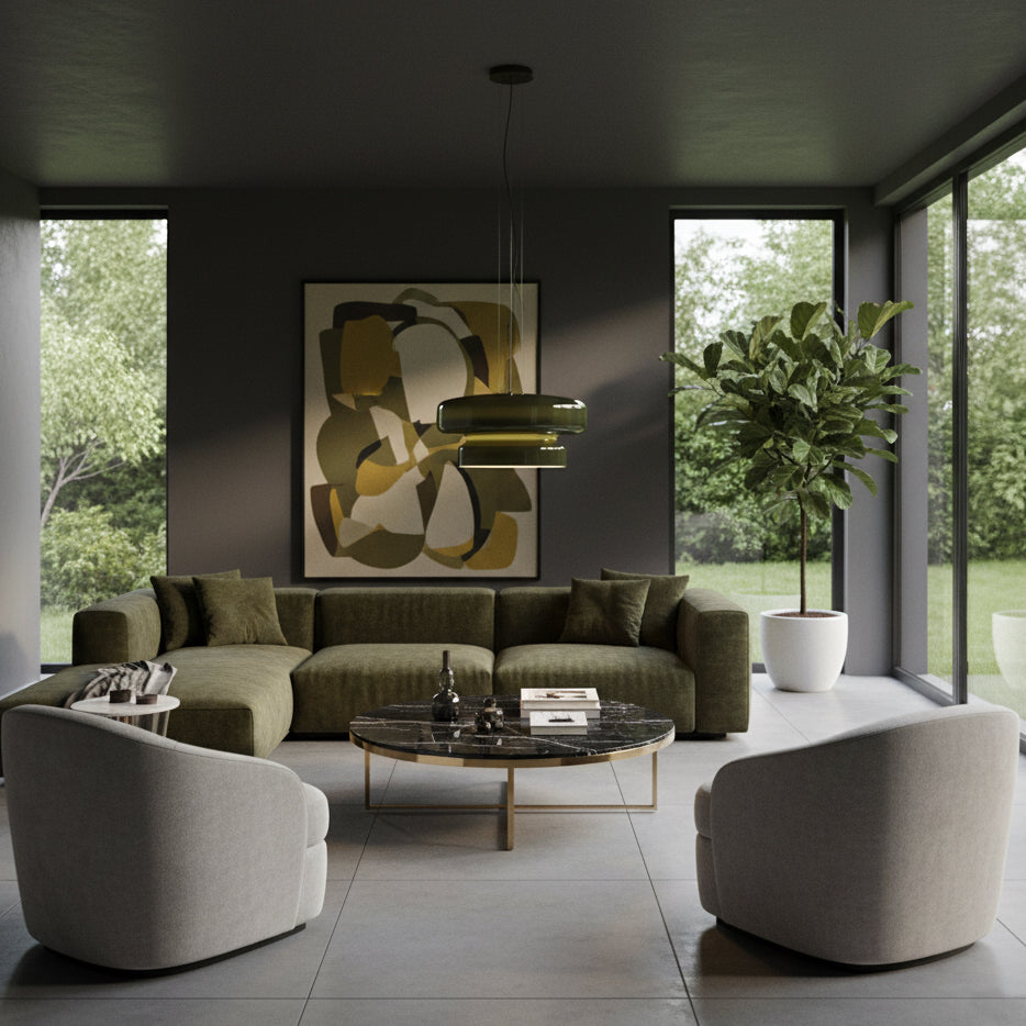 A Clérachic green glass pendant hangs in a dark living room with a green sofa, a round marble-topped coffee table and a large framed print.