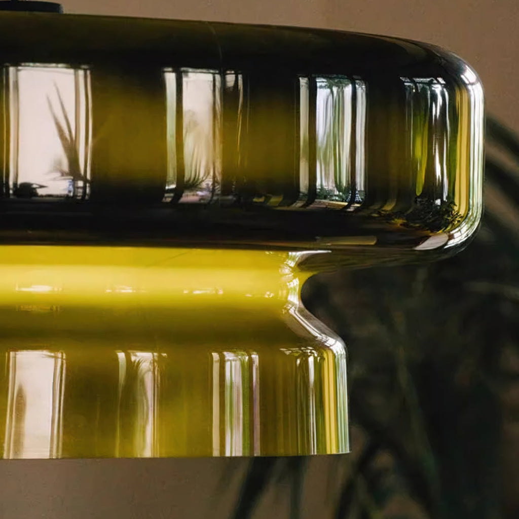Close view of the rounded rim and the yellow-green glow at the waist of this Clérachic green glass pendant.