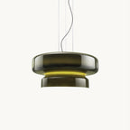 A Clérachic dark green glass pendant with a yellow-green glow between its two tiers, on a plain white backdrop.