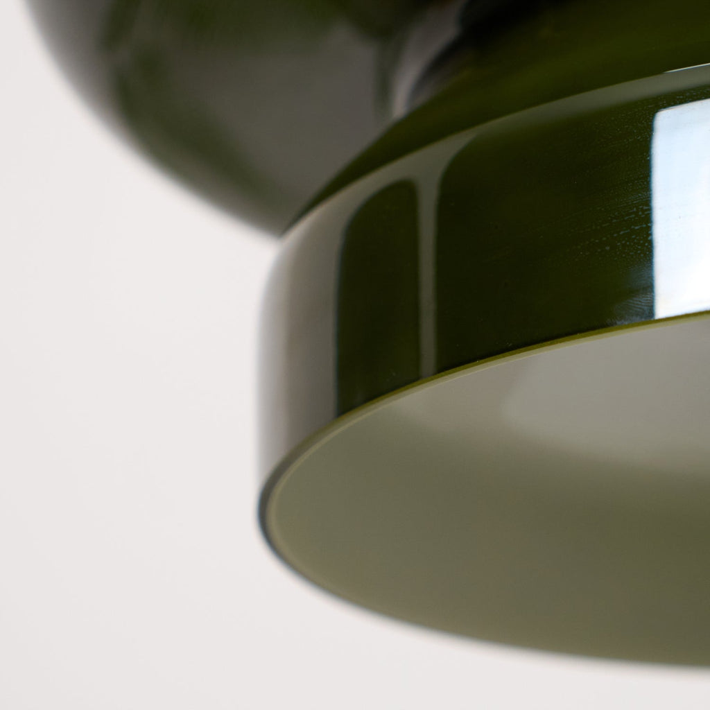 Close view of the lower rim of this Clérachic dark green glass pendant, with its pale inner shade visible.