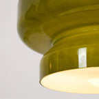 Close view of the stepped waist of this Clérachic green glass pendant, with warm light inside the lower tier.