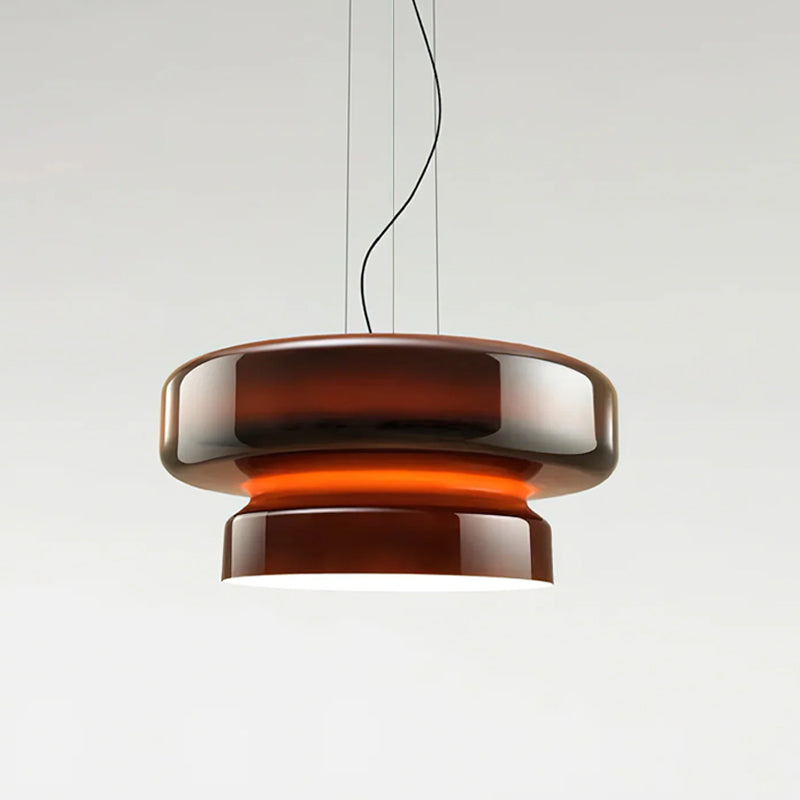 A Clérachic pendant in Amber Red glass, with a glowing orange band between its two tiers, on a pale backdrop.