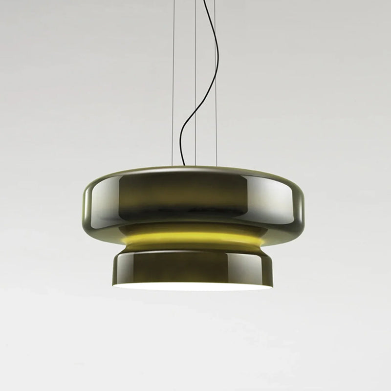 A Clérachic pendant in dark green glass, with a yellow glow between its two tiers, on a pale grey backdrop.