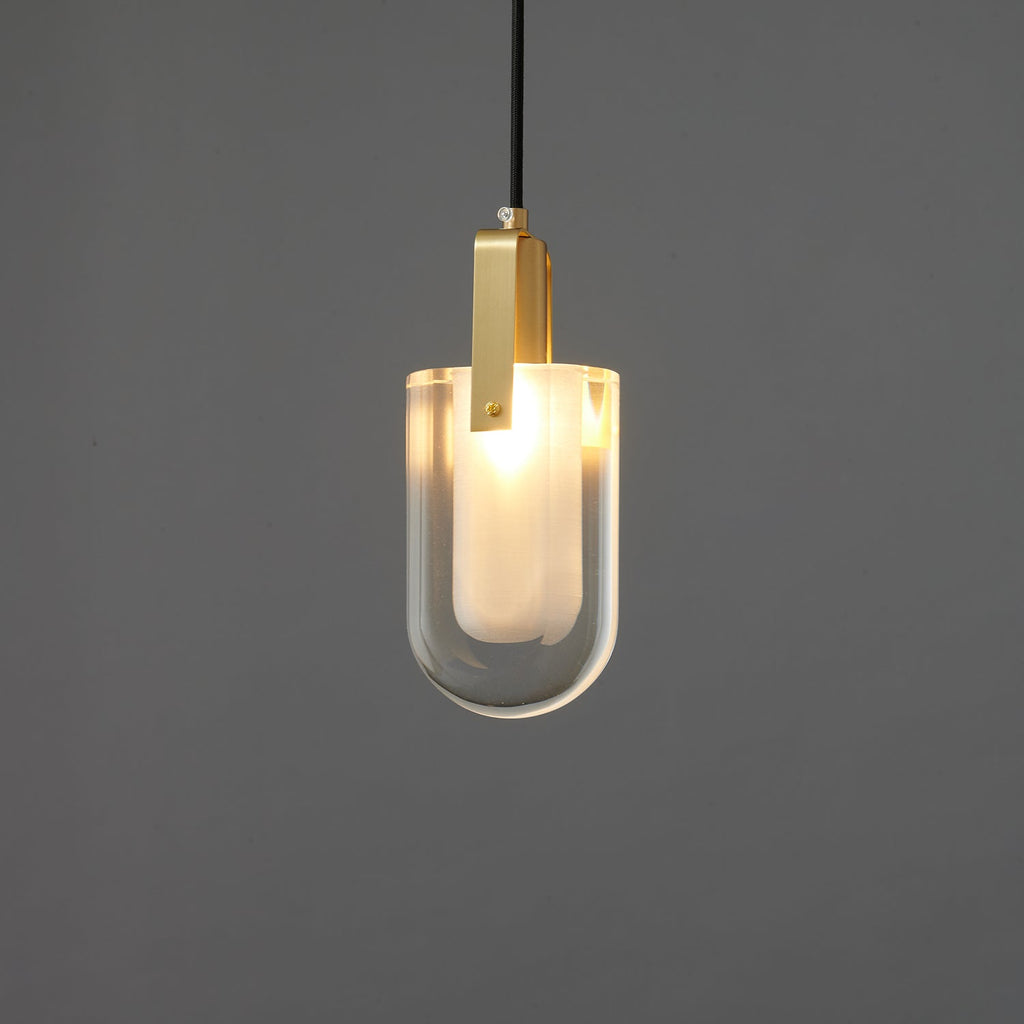 The U-shaped glass Clérachic pendant lit brighter, with a warm white glow through the frosted inner liner.