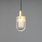 A smaller view of the lit U-shaped Clérachic pendant, with a brass bracket and a clear glass outer shade on grey.