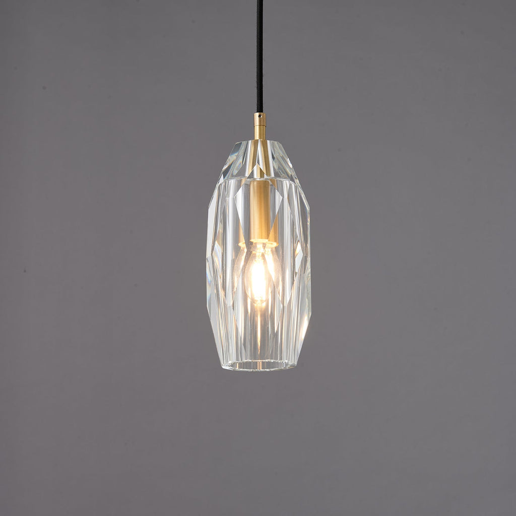 The faceted clear glass Clérachic pendant lit, with the filament bulb glowing through the cut glass.