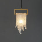 A close view of the lit draped glass Clérachic pendant, with a bright centre and a textured, sparkling glass surface.
