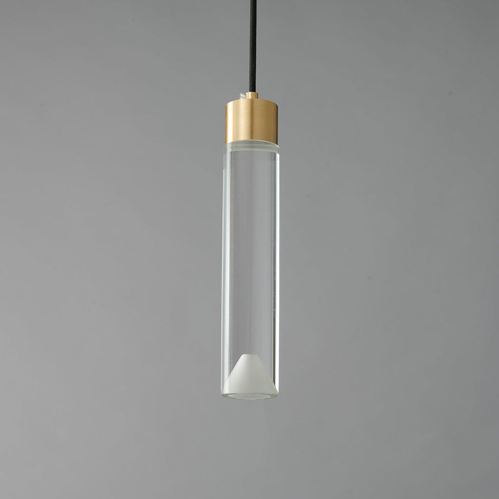 A Clérachic pendant with a long clear glass cylinder, a brass cap and a frosted cone at its base, unlit on grey.