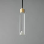 A Clérachic pendant with a long clear glass cylinder, a brass cap and a frosted cone at its base, unlit on grey.