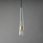 A slim clear glass Clérachic pendant tapering to a point at the top, with a brass fitting and a filament bulb inside, unlit.