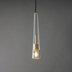 The tapered clear glass Clérachic pendant lit, with a warm filament bulb inside the glass cone.