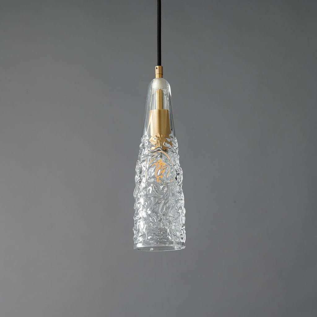 A Clérachic pendant with a crinkled, ice-textured clear glass shade tapering to a point around a brass fitting.