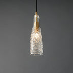 A lit Clérachic pendant with a crinkled glass shade, with a bright bulb glow inside and a brass fitting at the top.
