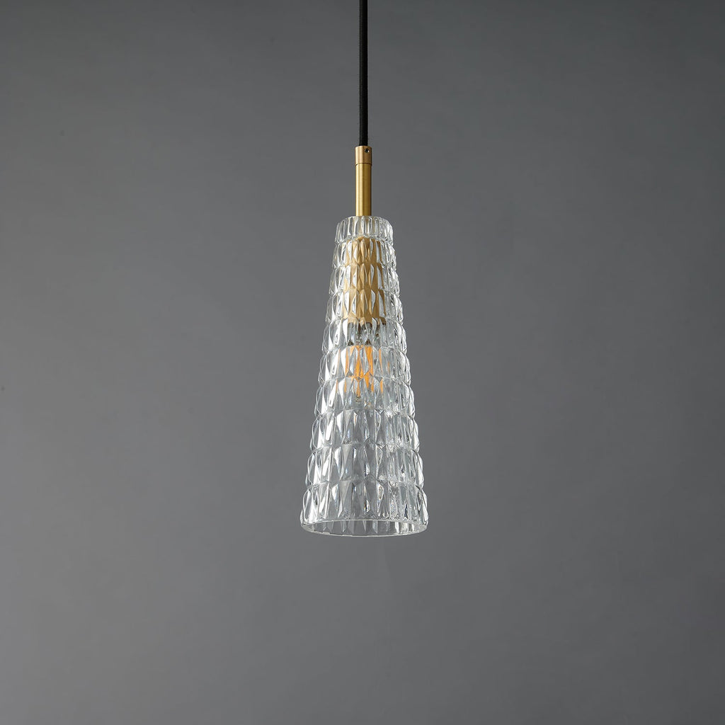 A Clérachic pendant with a tapered clear shade moulded in a diamond pattern, around a brass fitting and a filament bulb, unlit.