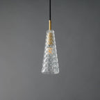 A Clérachic pendant with a tapered clear shade moulded in a diamond pattern, around a brass fitting and a filament bulb, unlit.