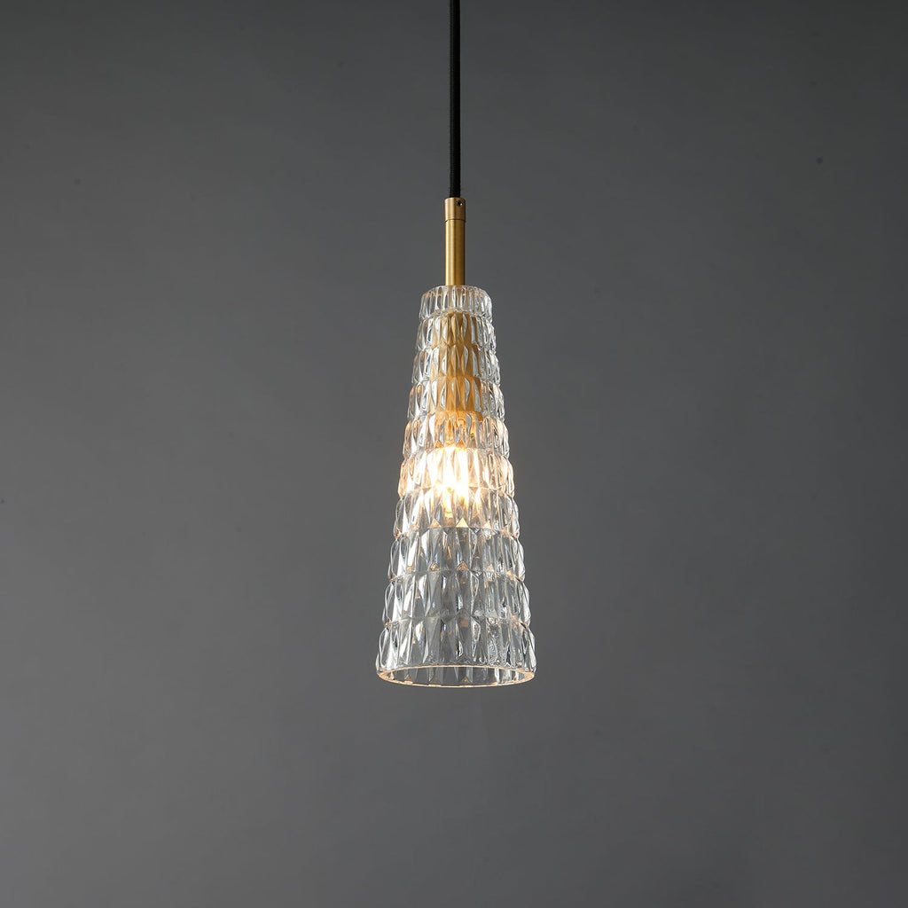 The diamond-patterned tapered Clérachic pendant lit, with the filament bulb glowing inside the moulded glass.