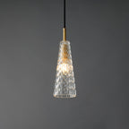 The diamond-patterned tapered Clérachic pendant lit, with the filament bulb glowing inside the moulded glass.