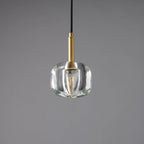 The rounded clear glass Clérachic pendant with a warm filament bulb inside, shown against a grey backdrop.