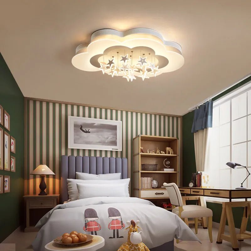 Clérachic cloud-shaped ceiling light with hanging white stars over a child's bedroom with green walls, a desk and a bookcase.