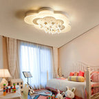Clérachic white cloud-shaped ceiling light with dangling stars in a bright nursery room with sheer curtains and soft toys.