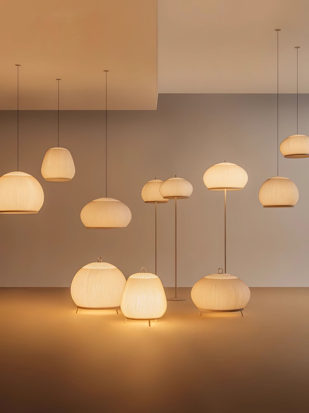 Clérachic knit lighting family lit together in one shot — pendants at three heights, two floor lamps, and three table lamps.