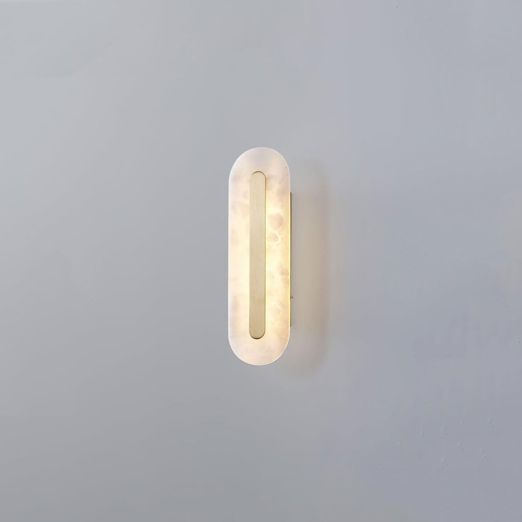 Clérachic Kristy wall lamp on grey in the compact size, brass strip inset in the alabaster oval.