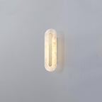 Clérachic Kristy wall lamp on grey in the compact size, brass strip inset in the alabaster oval.