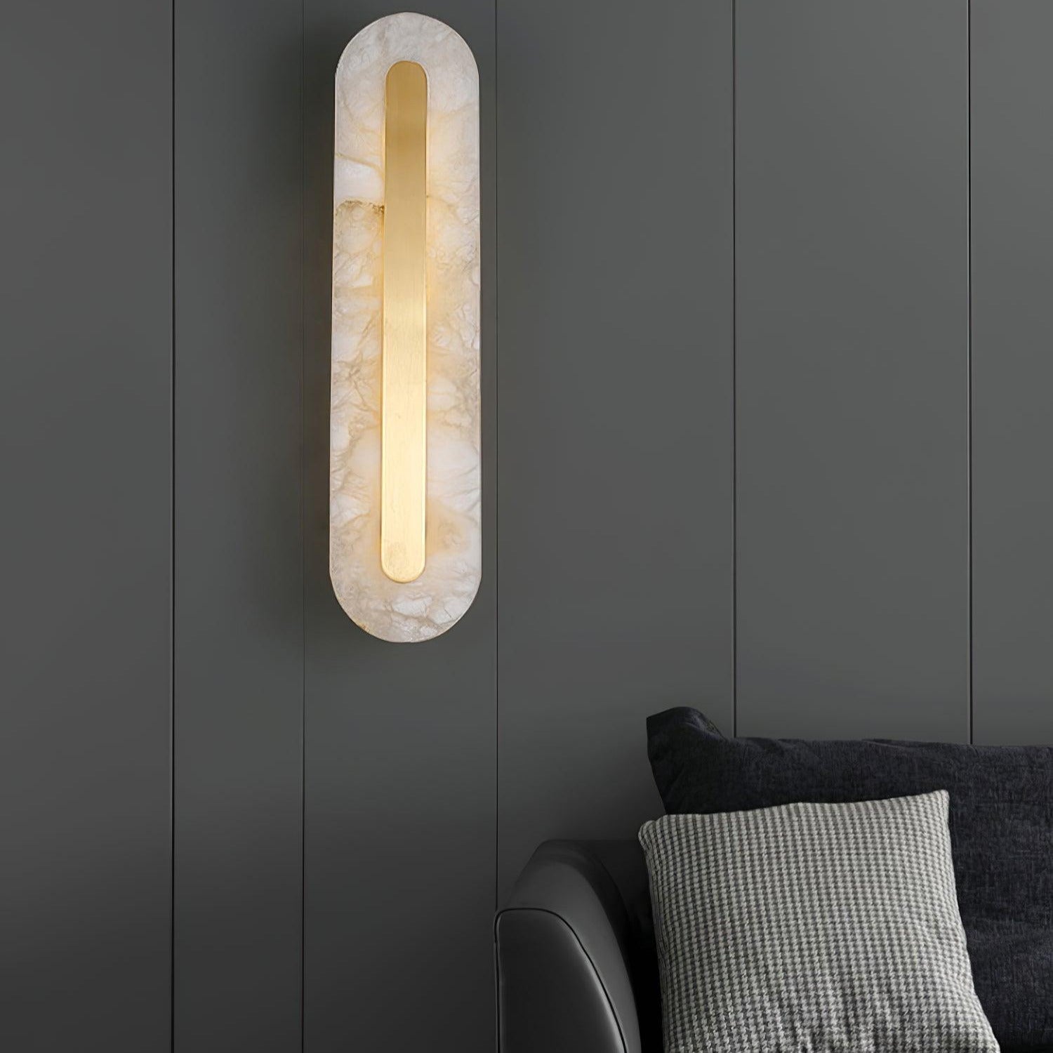 Clérachic Kristy wall lamp on grey panelling beside a sofa and checked cushion.