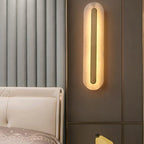 The Clérachic Kristy wall lamp on a ribbed wall beside a cream bed and gold trim.