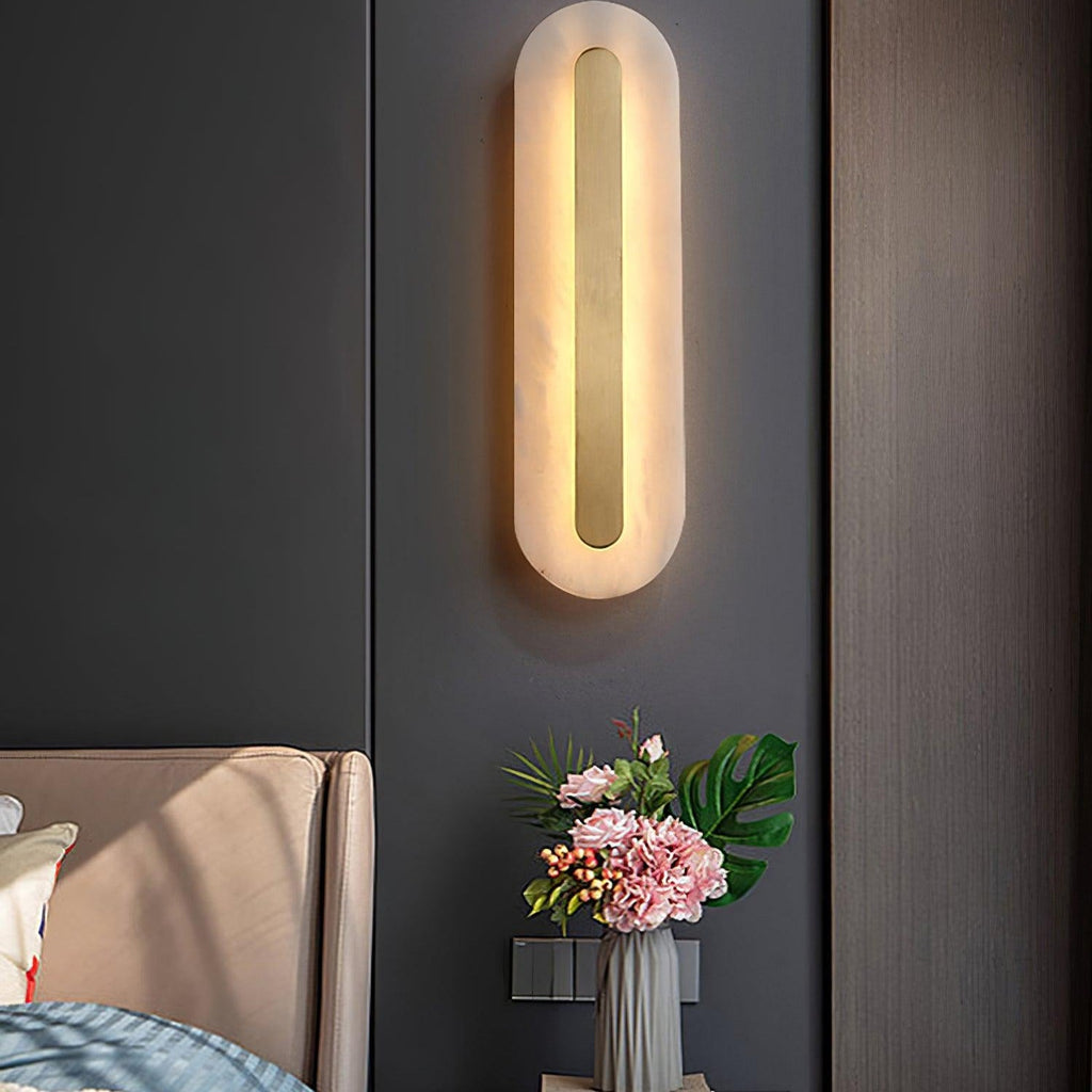 Clérachic Kristy wall lamp lit beside a bed with hydrangeas on the nightstand.