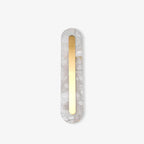 The Clérachic Kristy wall lamp on white in the narrow size, brass strip centred.