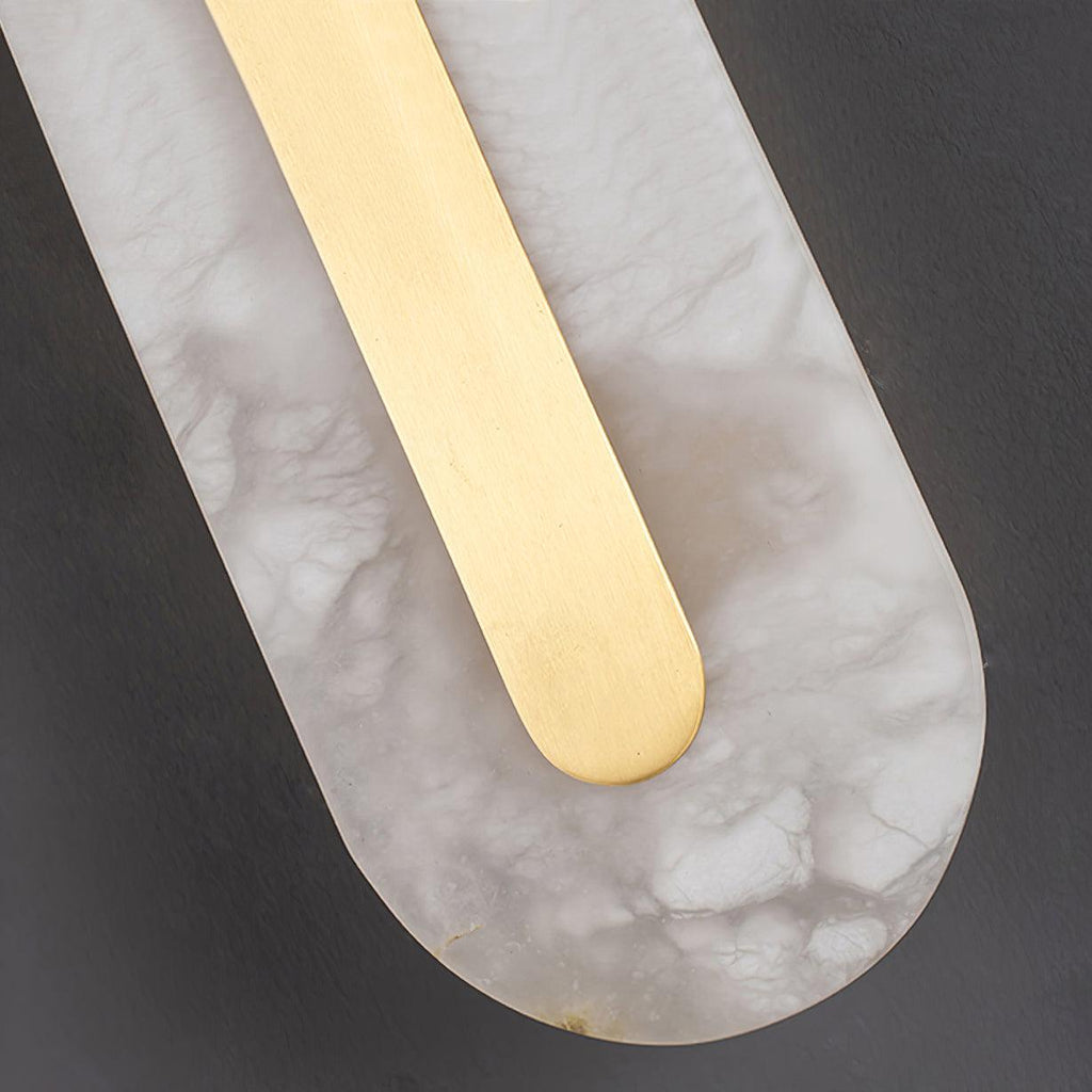 Macro of the Clérachic Kristy base, brass strip curving into the alabaster oval.
