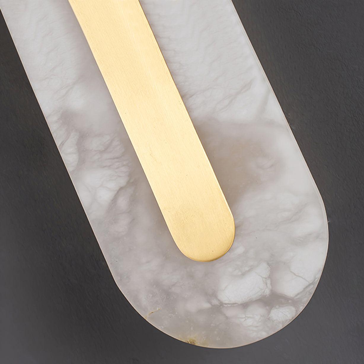 Macro of the Clérachic Kristy base, brass strip curving into the alabaster oval.