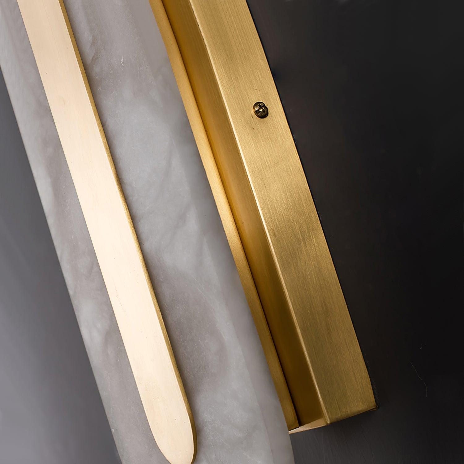 Close detail of the Clérachic Kristy brass channel meeting the edge of the stone.