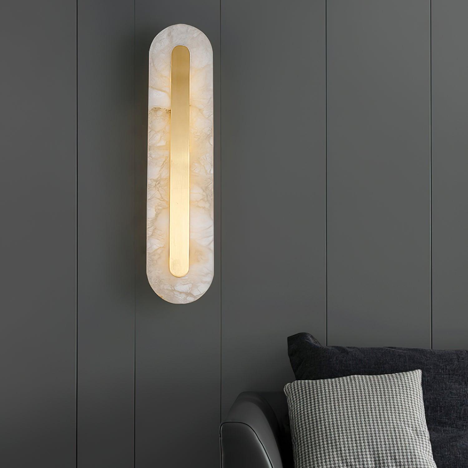 Clérachic Kristy wall lamp on green-grey panelling above a sofa and checked cushion.