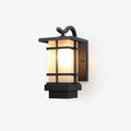 This Clérachic outdoor wall light on a plain backdrop, a black lantern with a curved bracket, frosted glass and a stepped base.