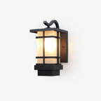 This Clérachic outdoor wall light on a plain backdrop, a black lantern with a curved bracket, frosted glass and a stepped base.