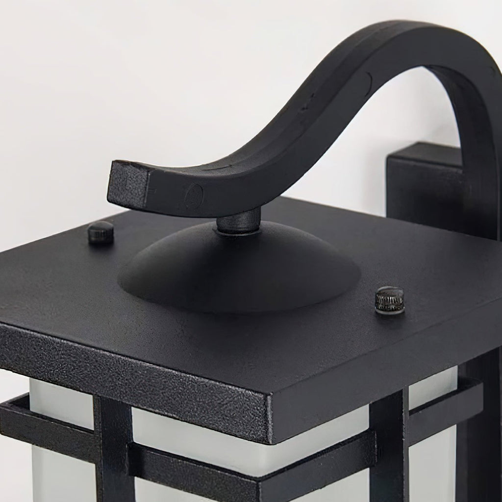 Close view of the curved bracket and square black roof of this Clérachic lantern wall light, with two small screws on top.