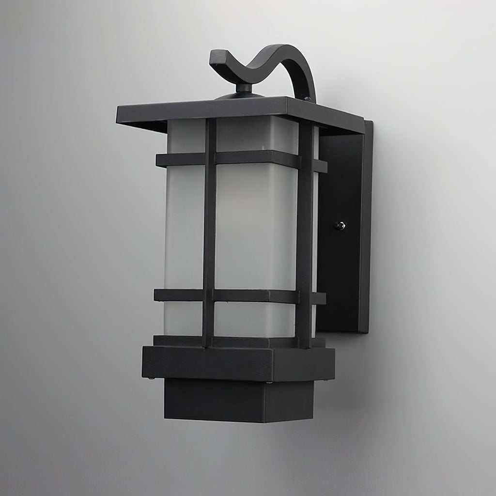 Wall-mounted Clérachic lantern in black aluminium, shown close up against a grey wall, its frosted glass in a grid frame.