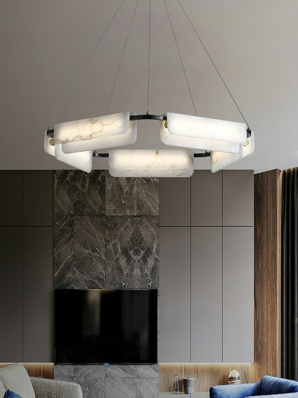 Clérachic Layered Alabaster Plate Chandelier lighting a living room above a marble media wall and blue velvet seating.