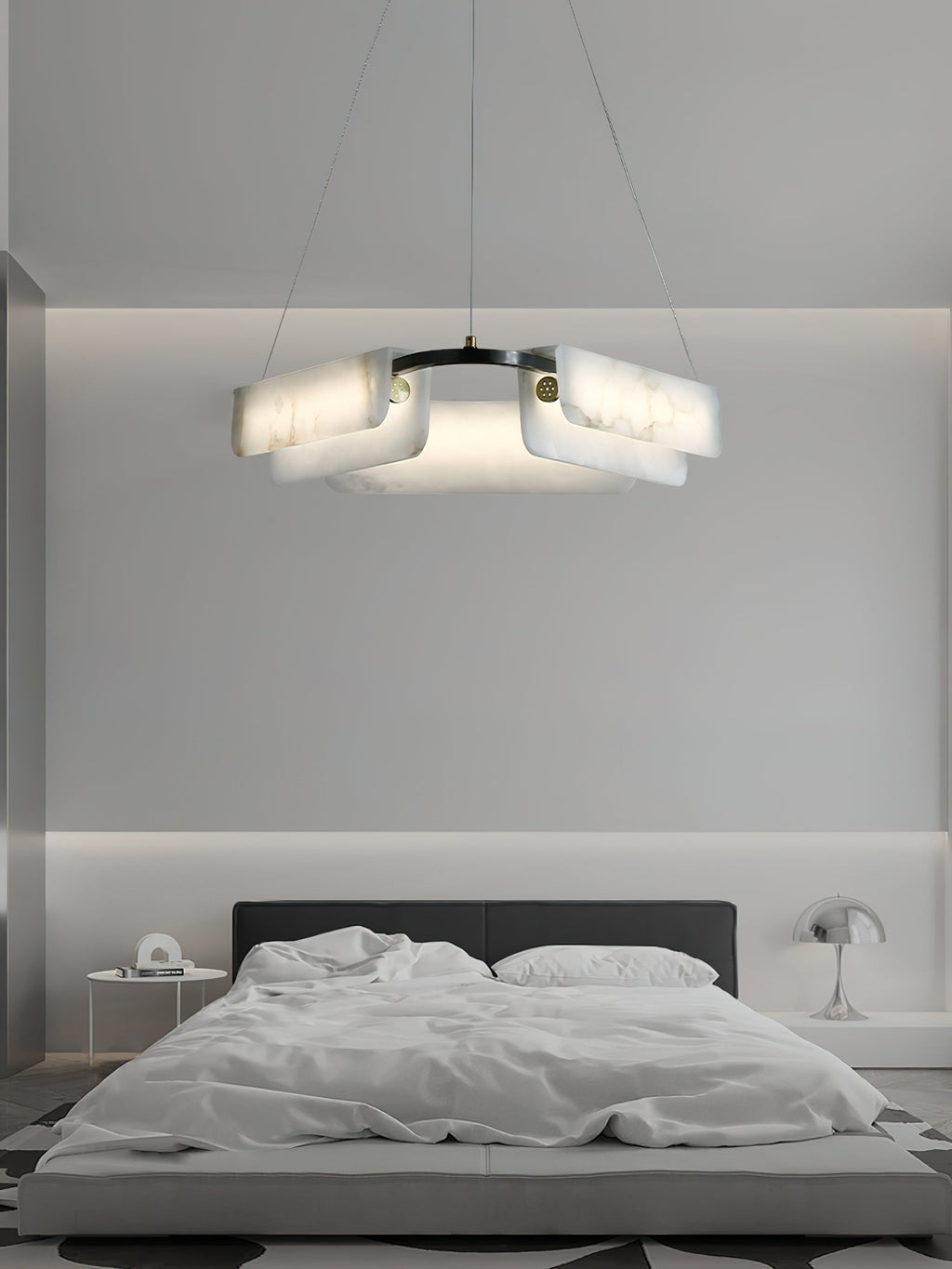 Clérachic Layered Alabaster Plate Chandelier above a low platform bed, glowing softly in a pale grey bedroom.